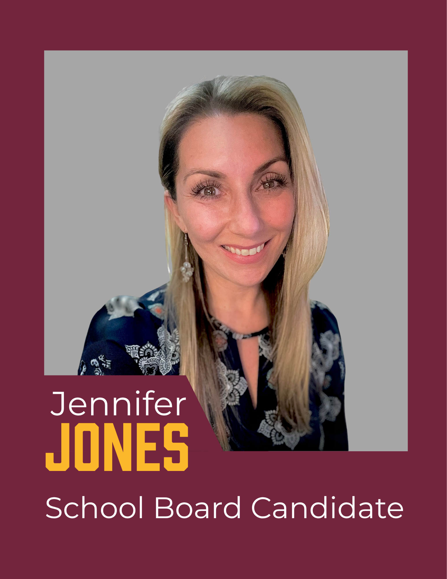 A blonde woman smiling at the camera wearing a floral blue blouse 